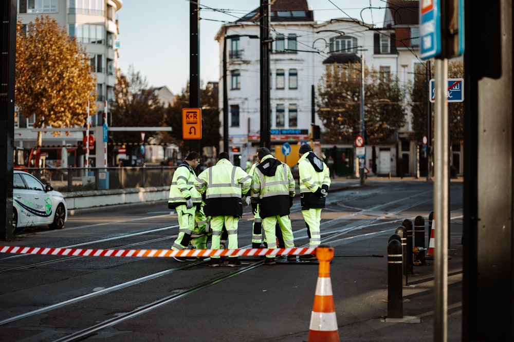 a group of firefighters standing on the side of a street