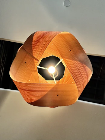 A modern pendant with a blend of traditional and contemporary design, showcased on a wooden surface.