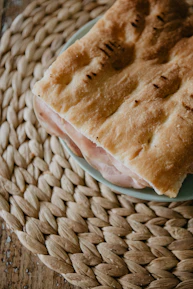 Close-up of a signature Damascus bite wrapped in delicate flatbread on a rustic wooden board.