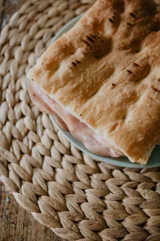 Close-up of a signature Damascus bite wrapped in delicate flatbread on a rustic wooden board.