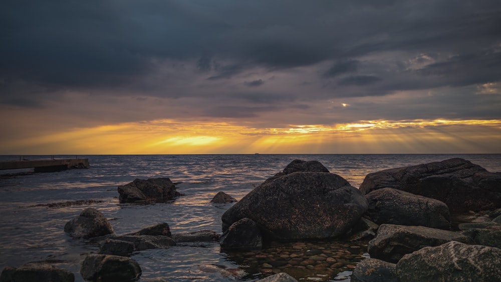 a rocky beach with a sunset