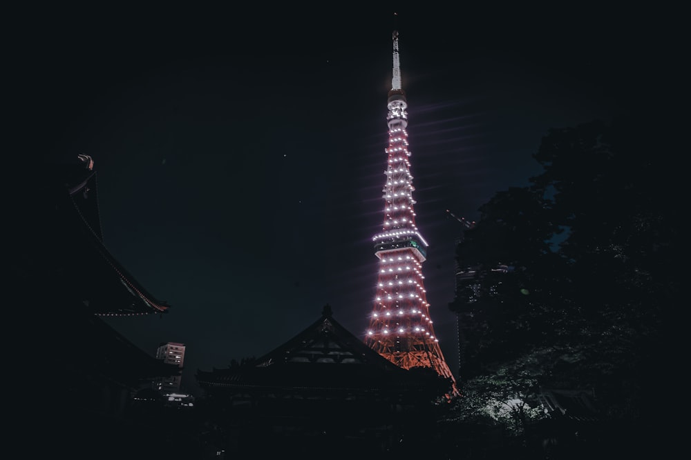 a tall tower lit up at night with Tokyo Tower in the background