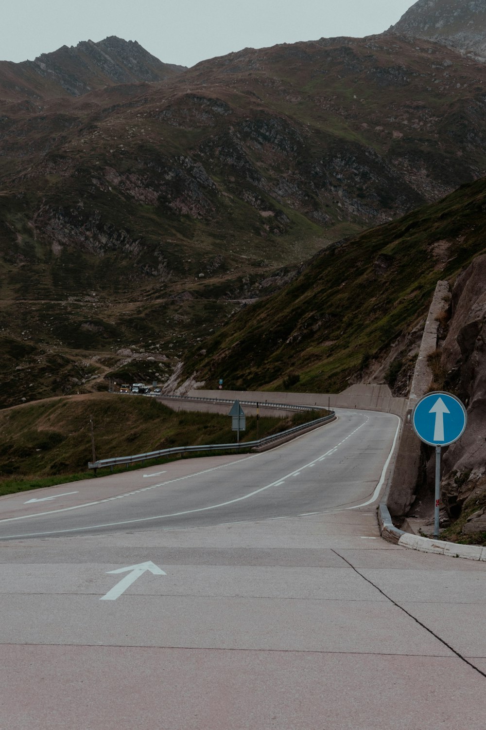 a road with a sign on it and mountains in the background