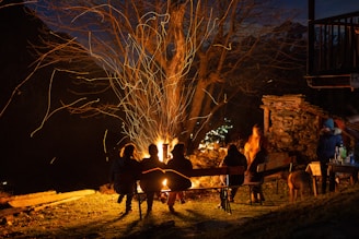 Community members sharing traditional food and stories around a campfire.