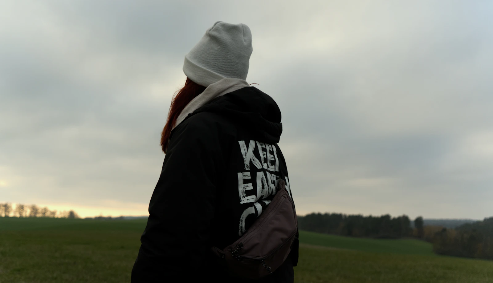 A person wearing a hoodie outdoors, suggesting comfort and everyday spiritual style