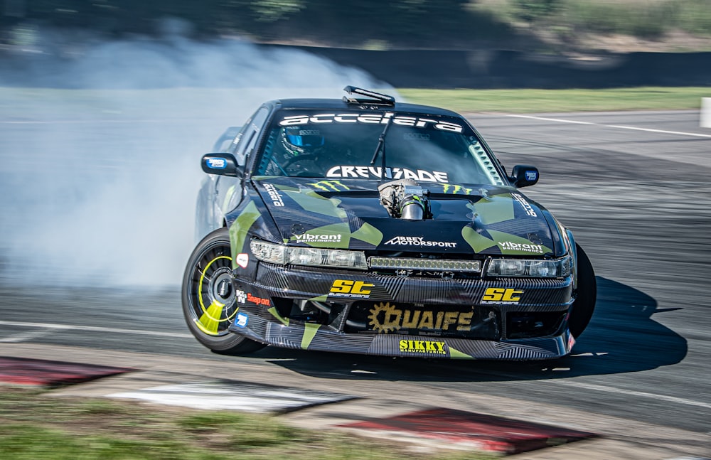 a car with smoke coming out of it driving on a track