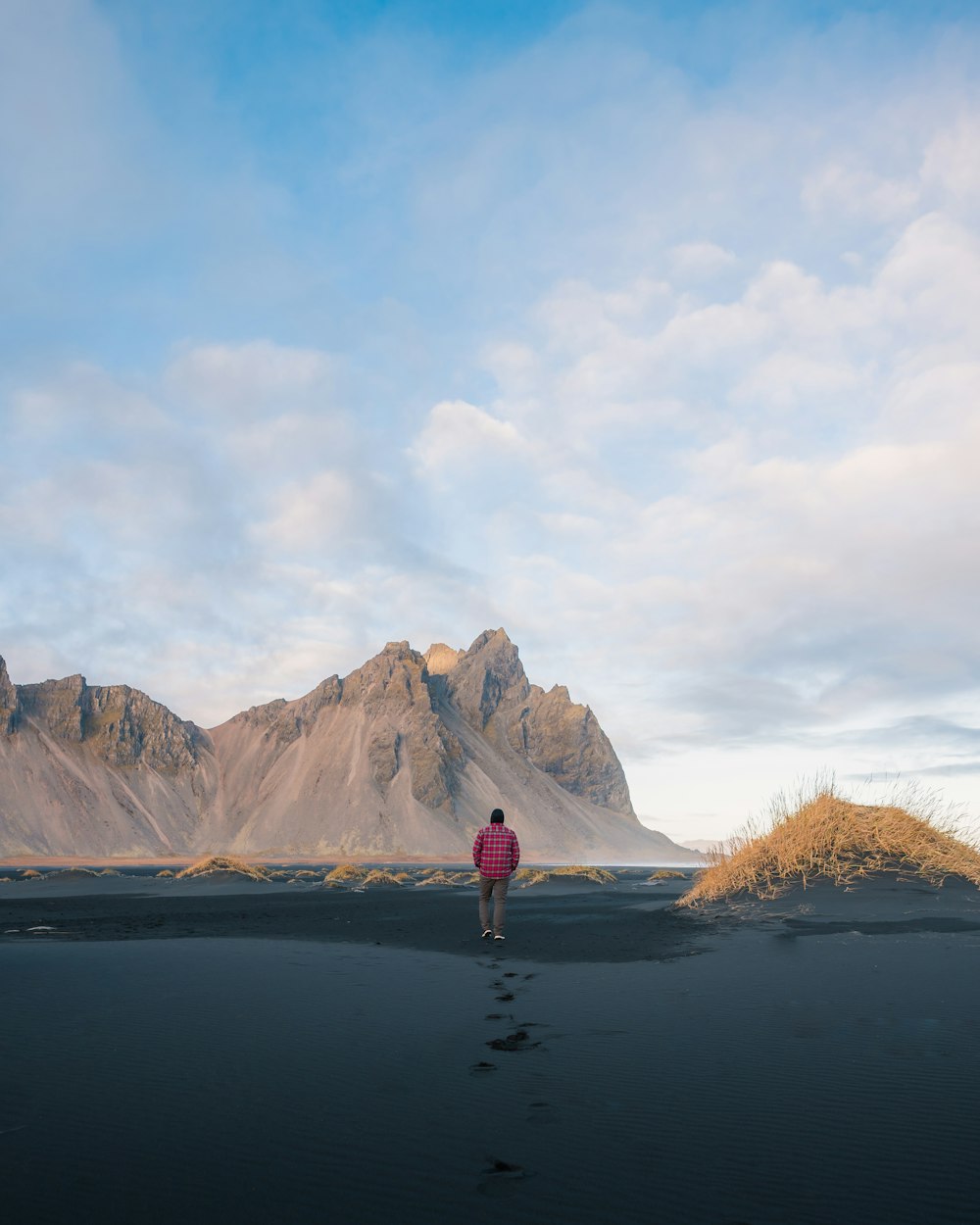 a person standing in a body of water with a mountain in the background