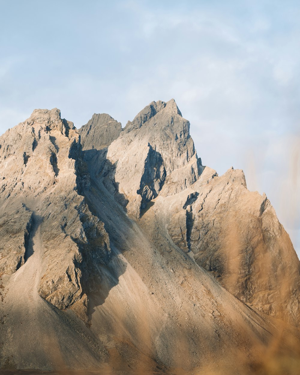 a rocky mountain with a blue sky