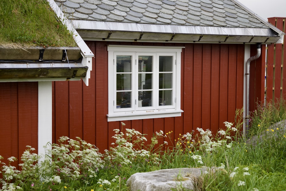 uma casa vermelha com uma janela branca