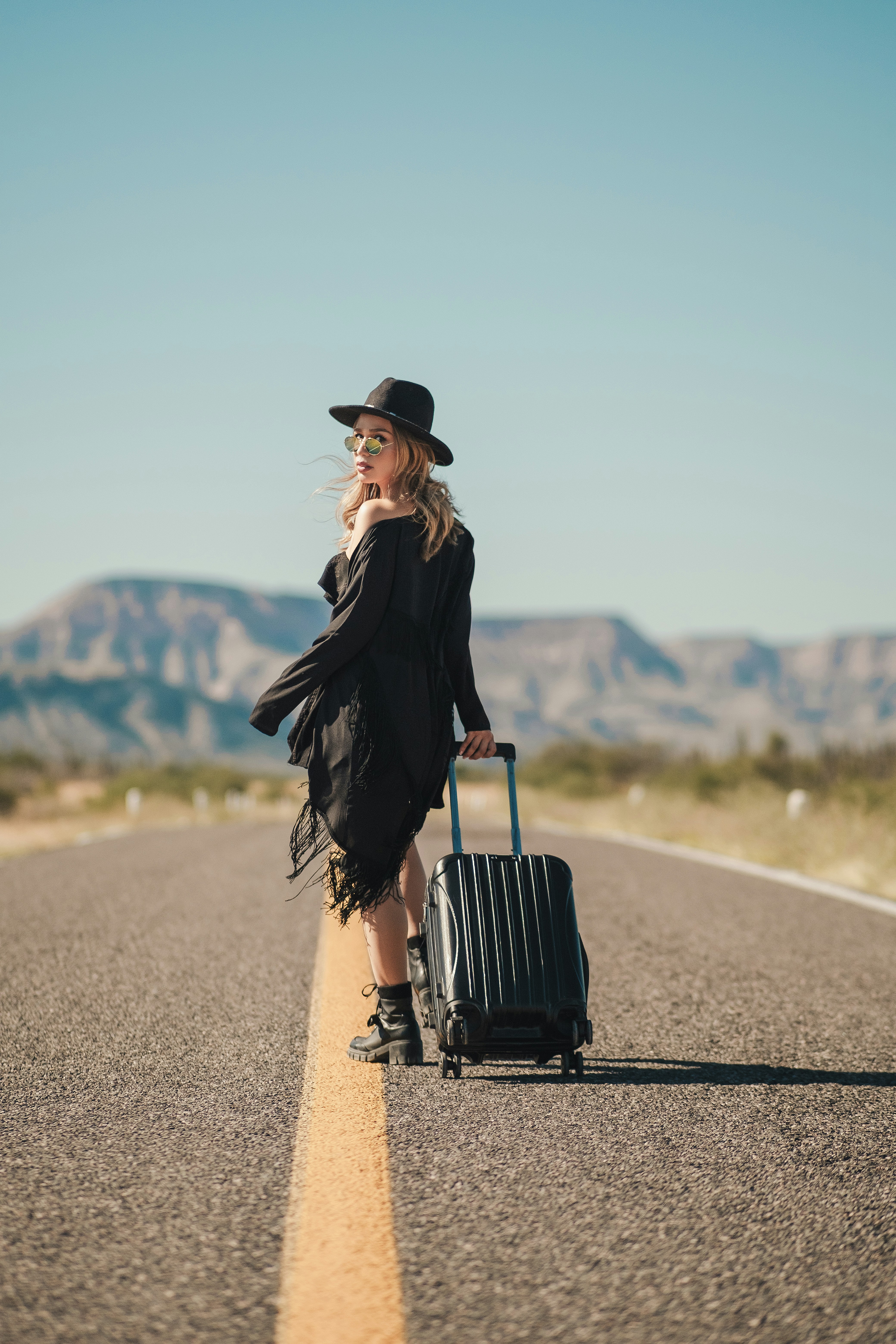 a person with a suitcase walking on a road