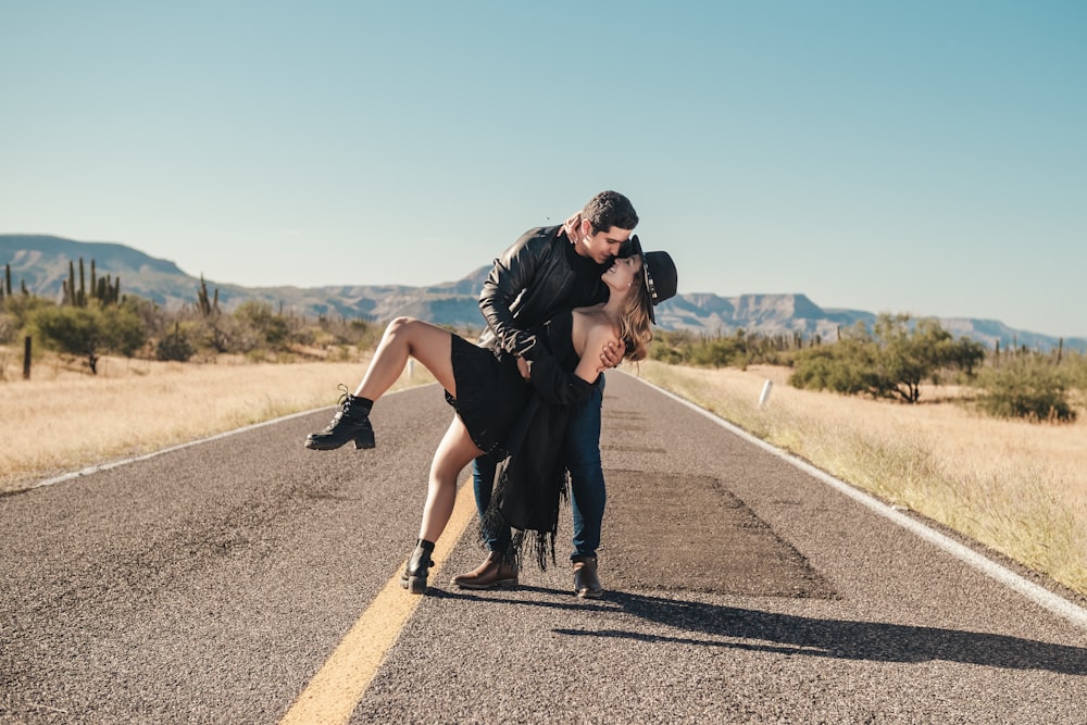 a man holding a woman on a road