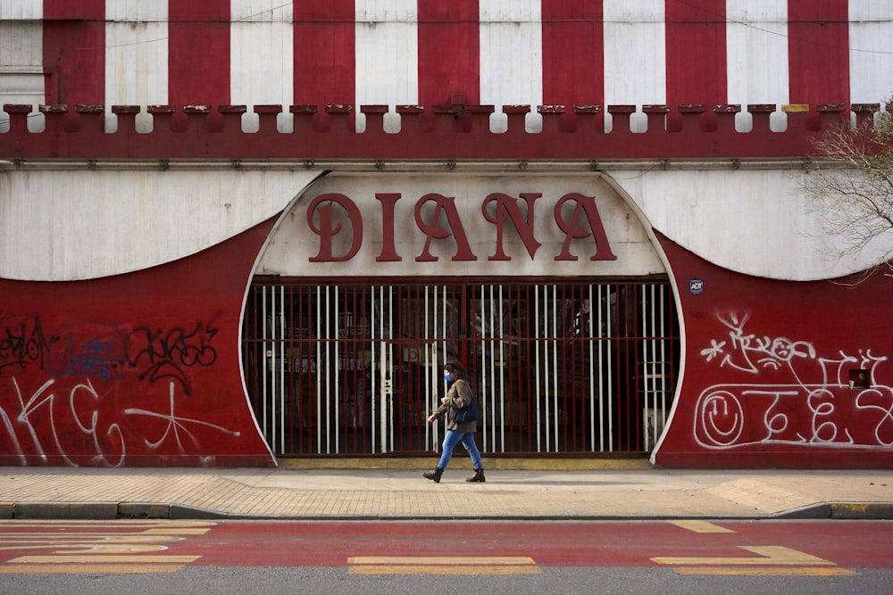 a person walking in front of a building with graffiti on it