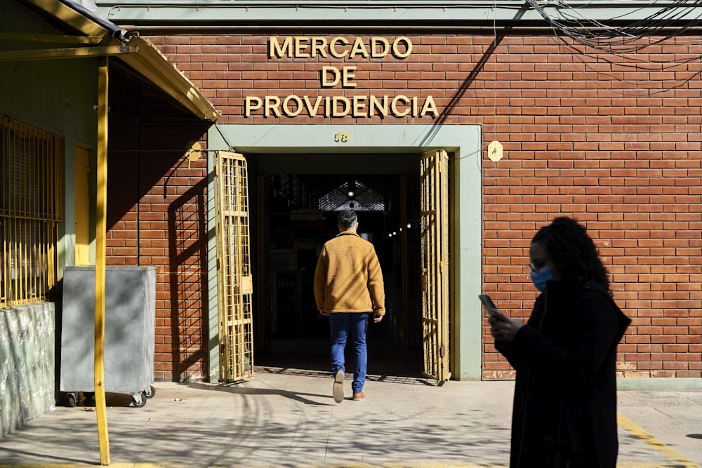 a man and woman walking out of a building