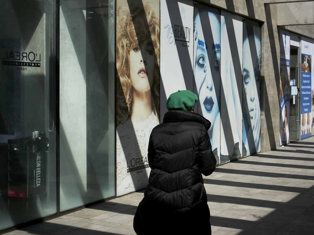 a person walking in front of a wall with art