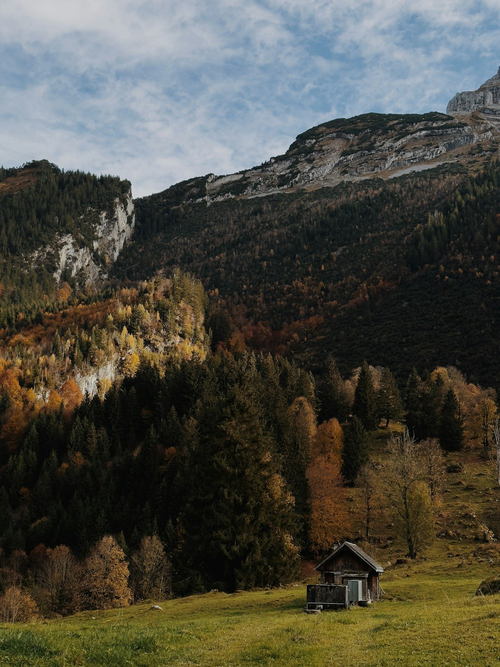 a small house in a valley between mountains