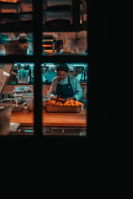Close-up of a chef skillfully preparing fresh ingredients in a lively kitchen.