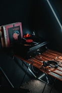Vinyl records and music production gear on a wooden table.