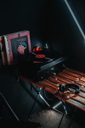 A vintage vinyl record next to a modern audio workstation displaying waveforms.