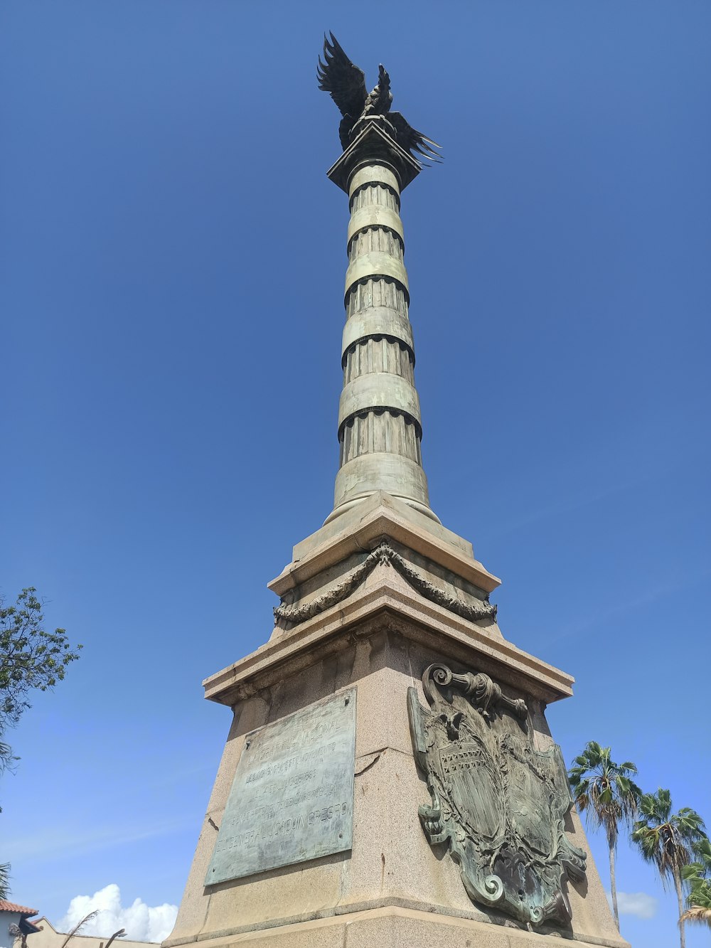 ein hoher Turm mit einer Statue auf der Spitze