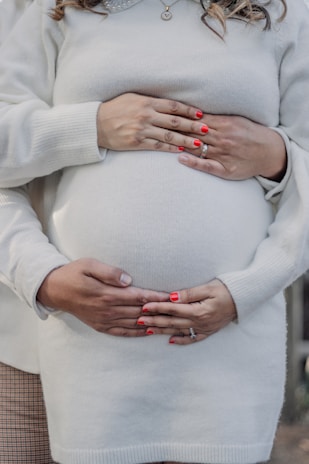 Close-up of hands gently holding a pregnancy test, symbolizing support through all stages of care.