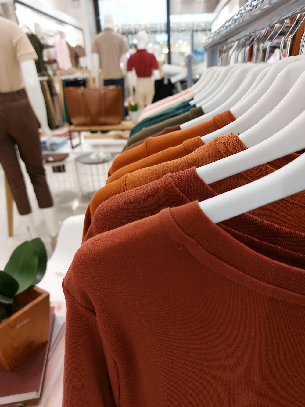 Una fila de camisas colgadas en un estante en una tienda de ropa