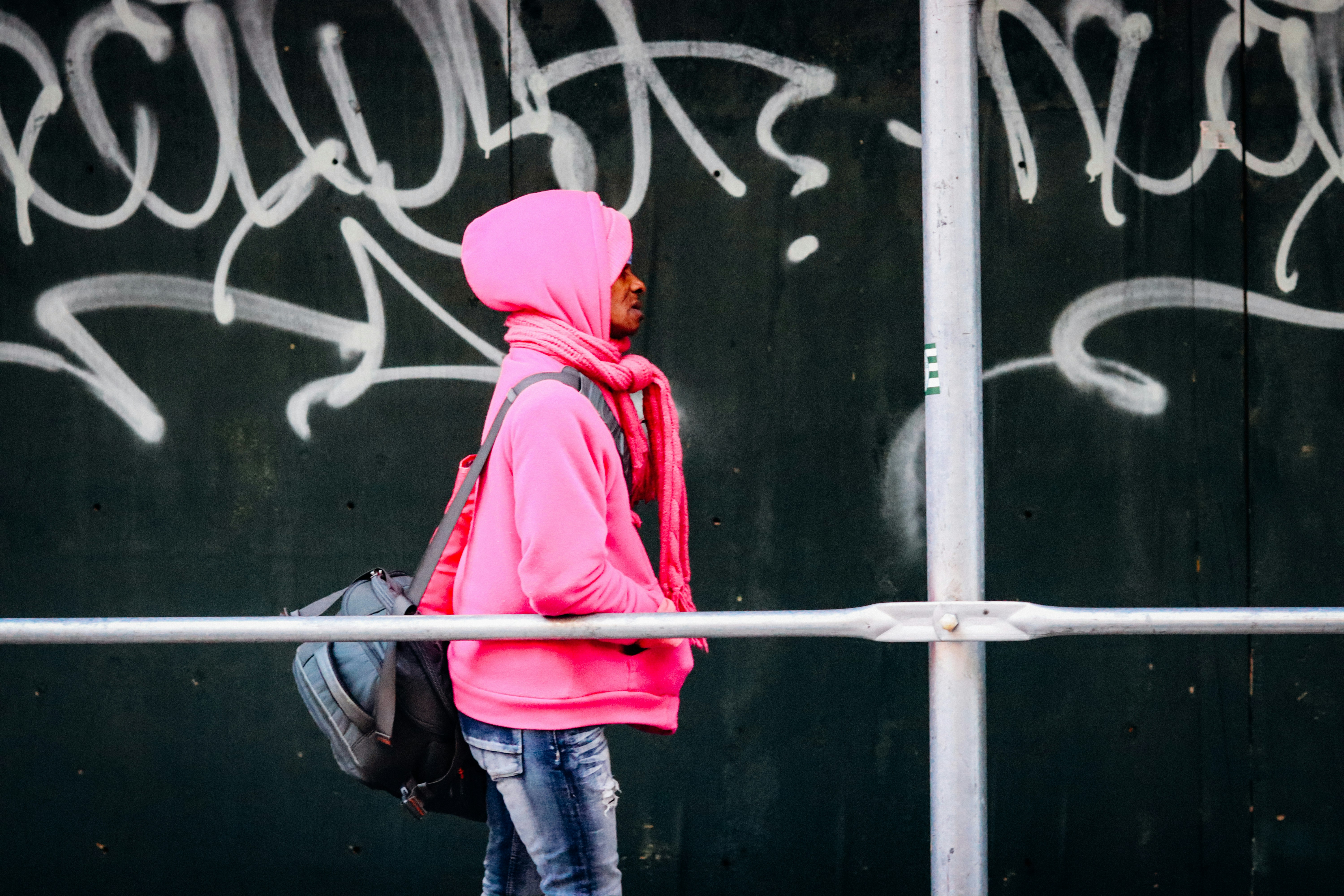 a person standing in front of a wall with graffiti