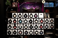 Vinyl records stacked on a shelf in a cozy music studio environment.