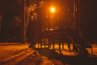 A playground safety consultant carefully examining playground equipment under bright daylight.