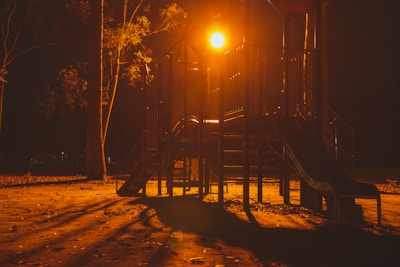 A playground safety consultant carefully examining playground equipment under bright daylight.