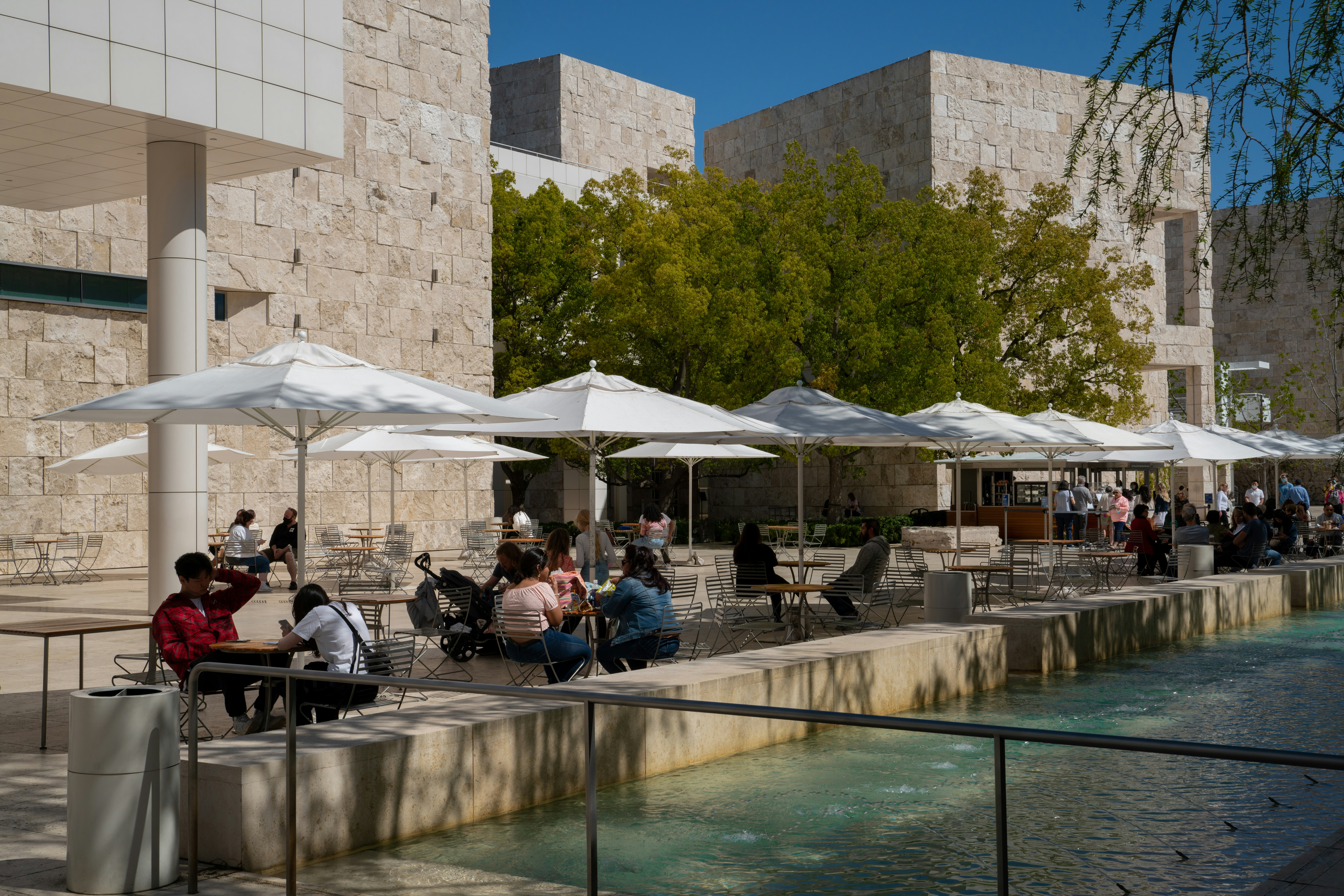 a group of people sitting at tables outside