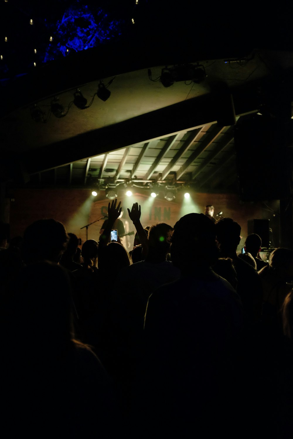 a crowd of people in a dark room with a stage and lights