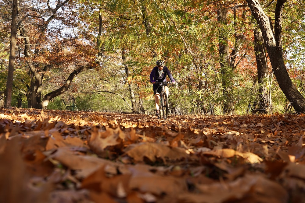 a person riding a bike on a trail in the woods