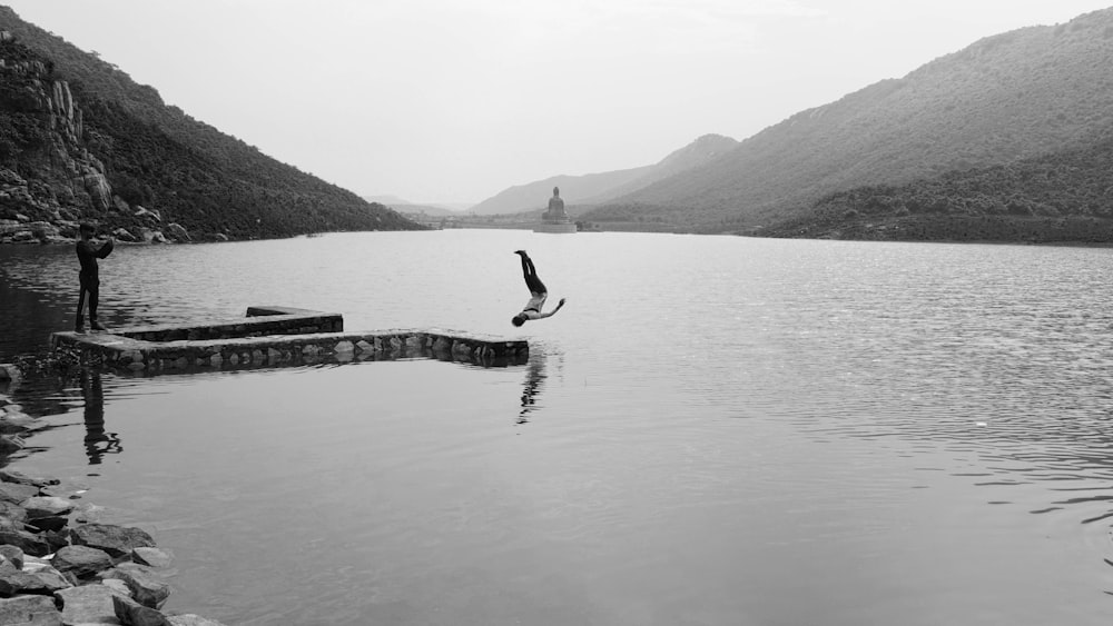 a person standing on a dock in a lake