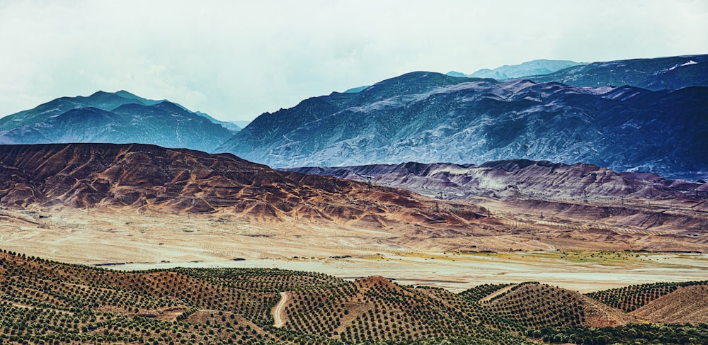 a landscape with hills and a body of water in the distance