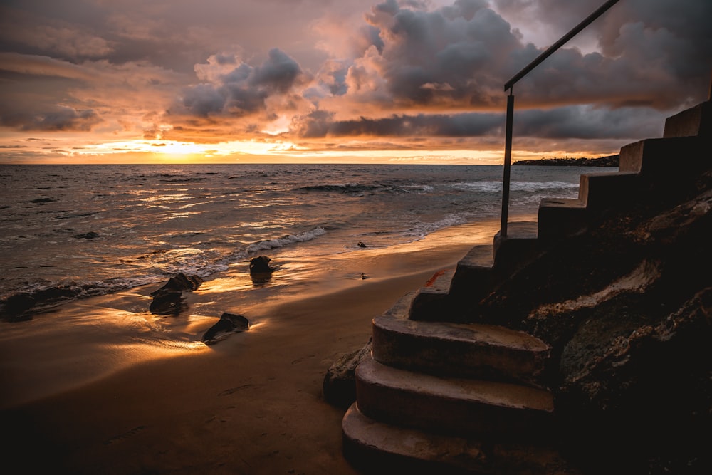 a beach with rocks and a lamp post