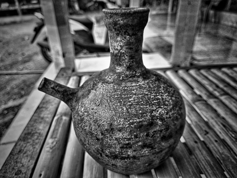 a metal bell on a wooden bench