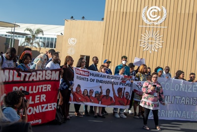 Human rights defenders holding banners advocating for climate and environmental justice.