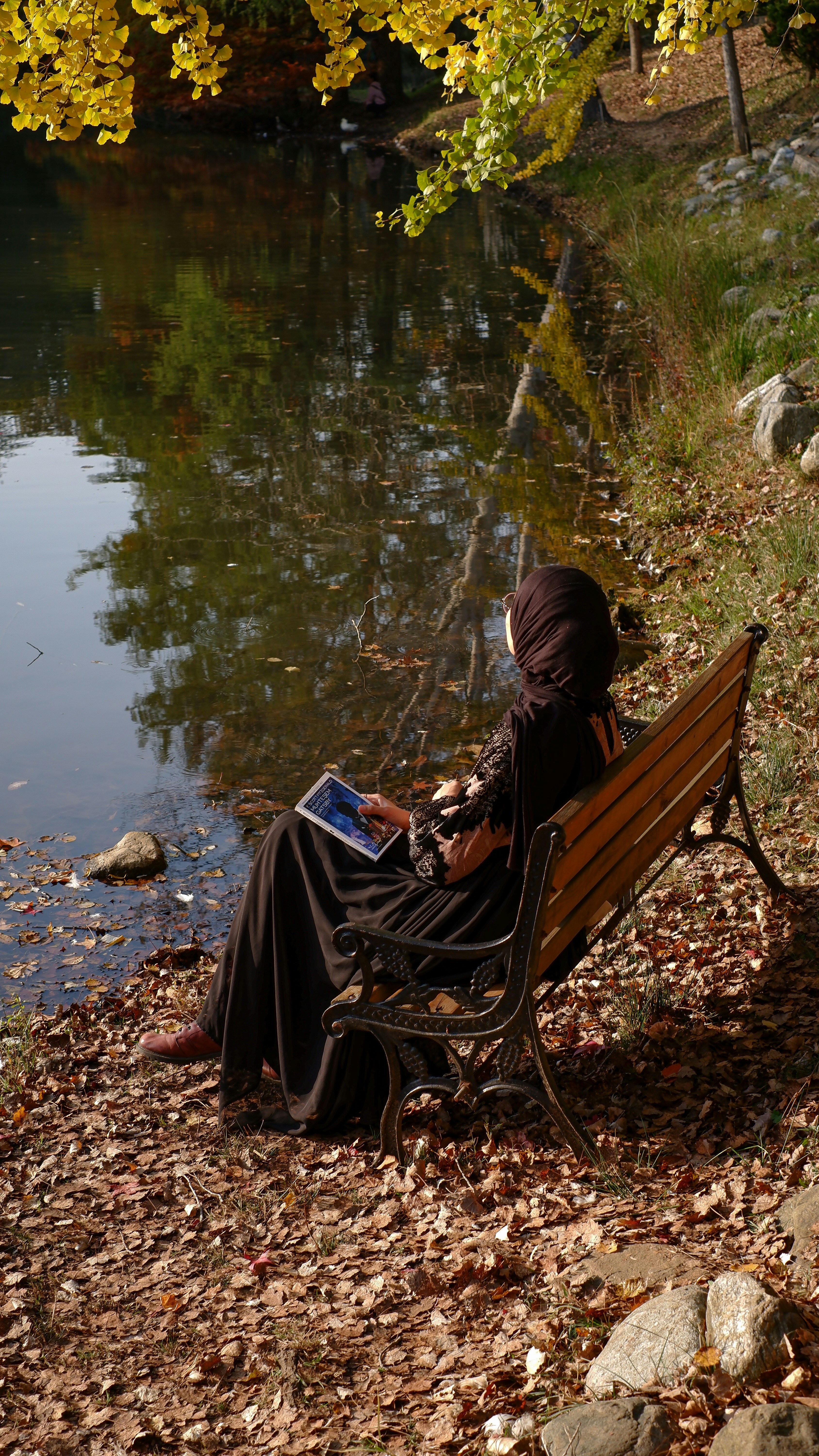 a person sitting on a bench reading a book