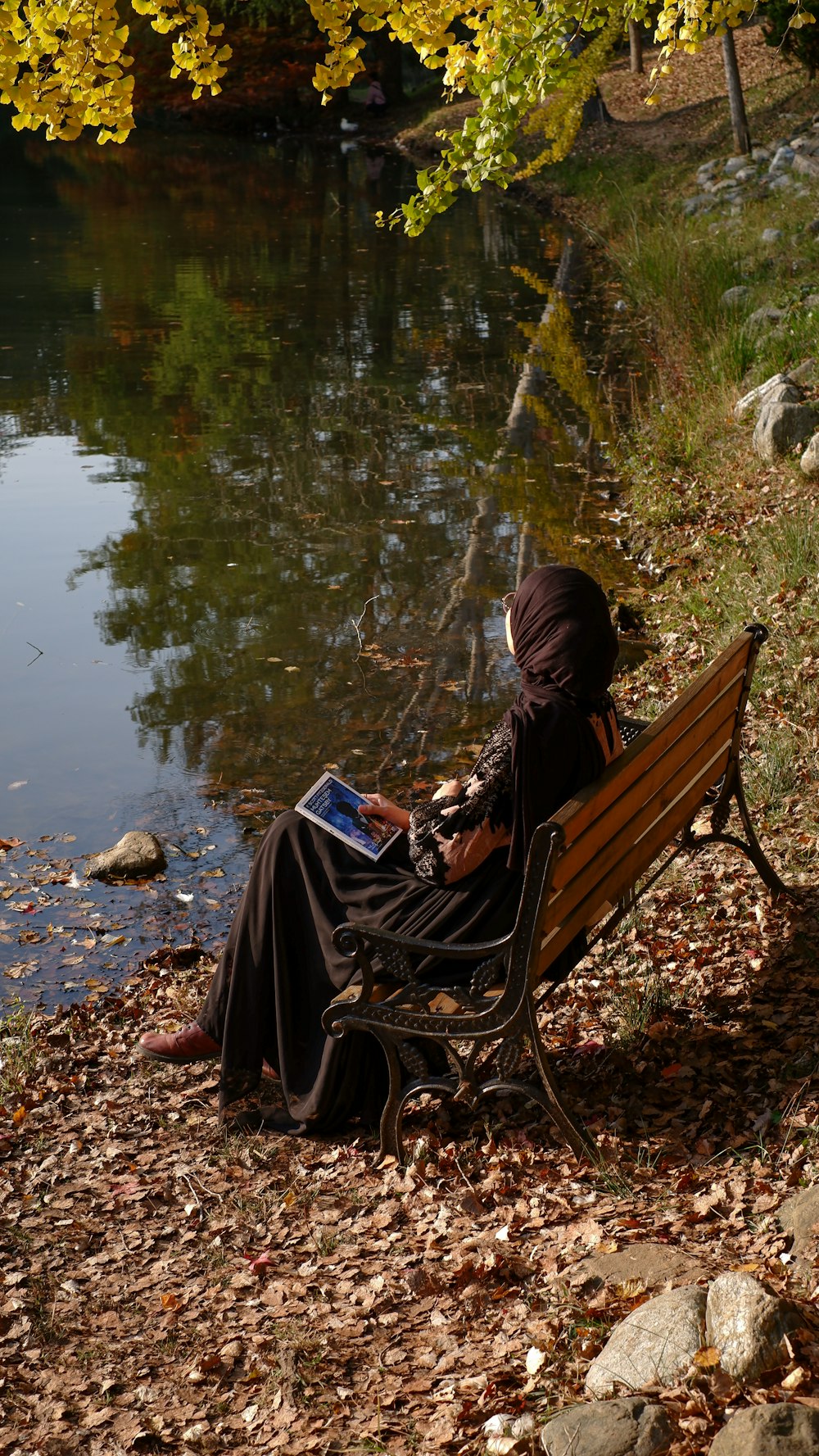 a person sitting on a bench reading a book