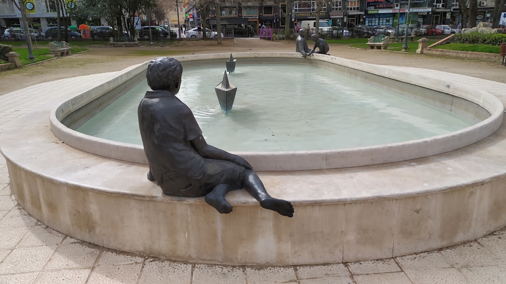 a statue of a person sitting in a fountain