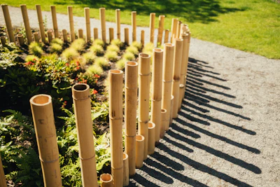 A bamboo post garden border beside a path, with colourful flower bedding and a clean grass edge in t