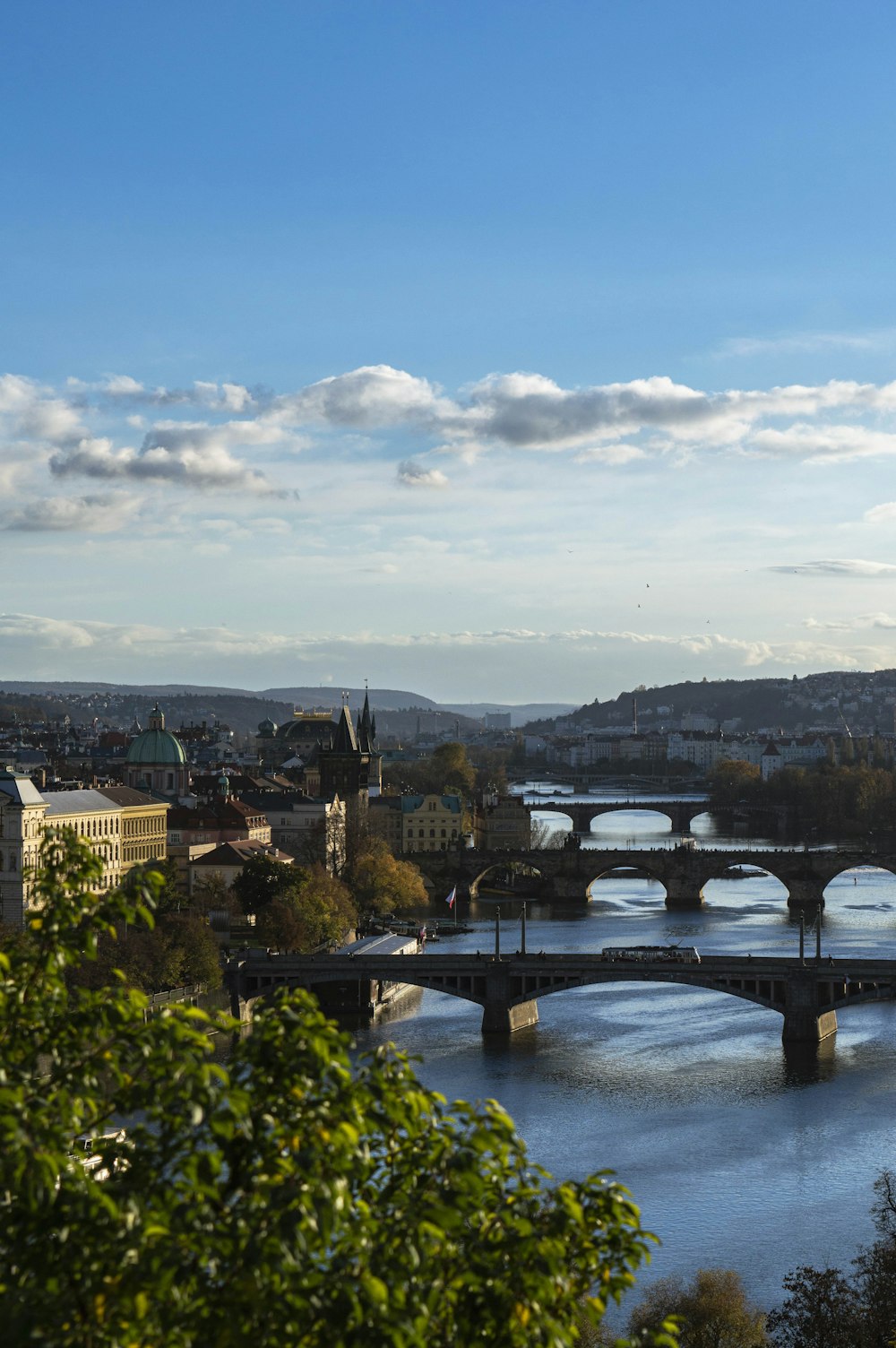 a bridge over a river with a city in the background