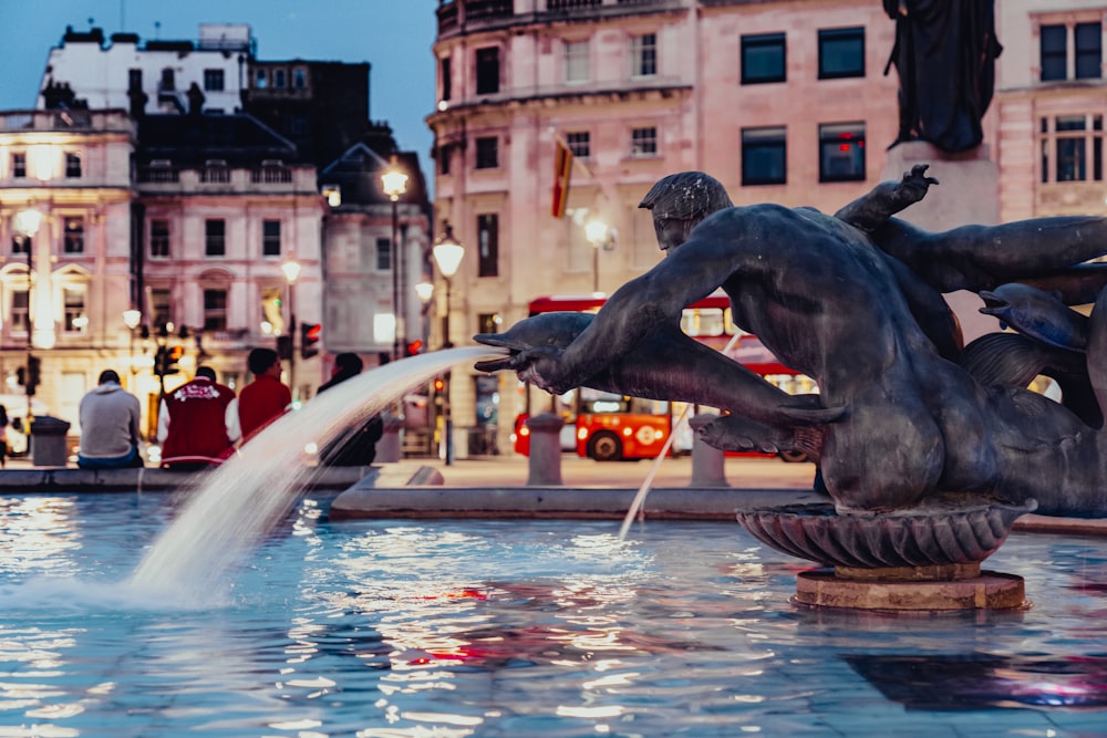 a statue of a bull in a fountain in a city