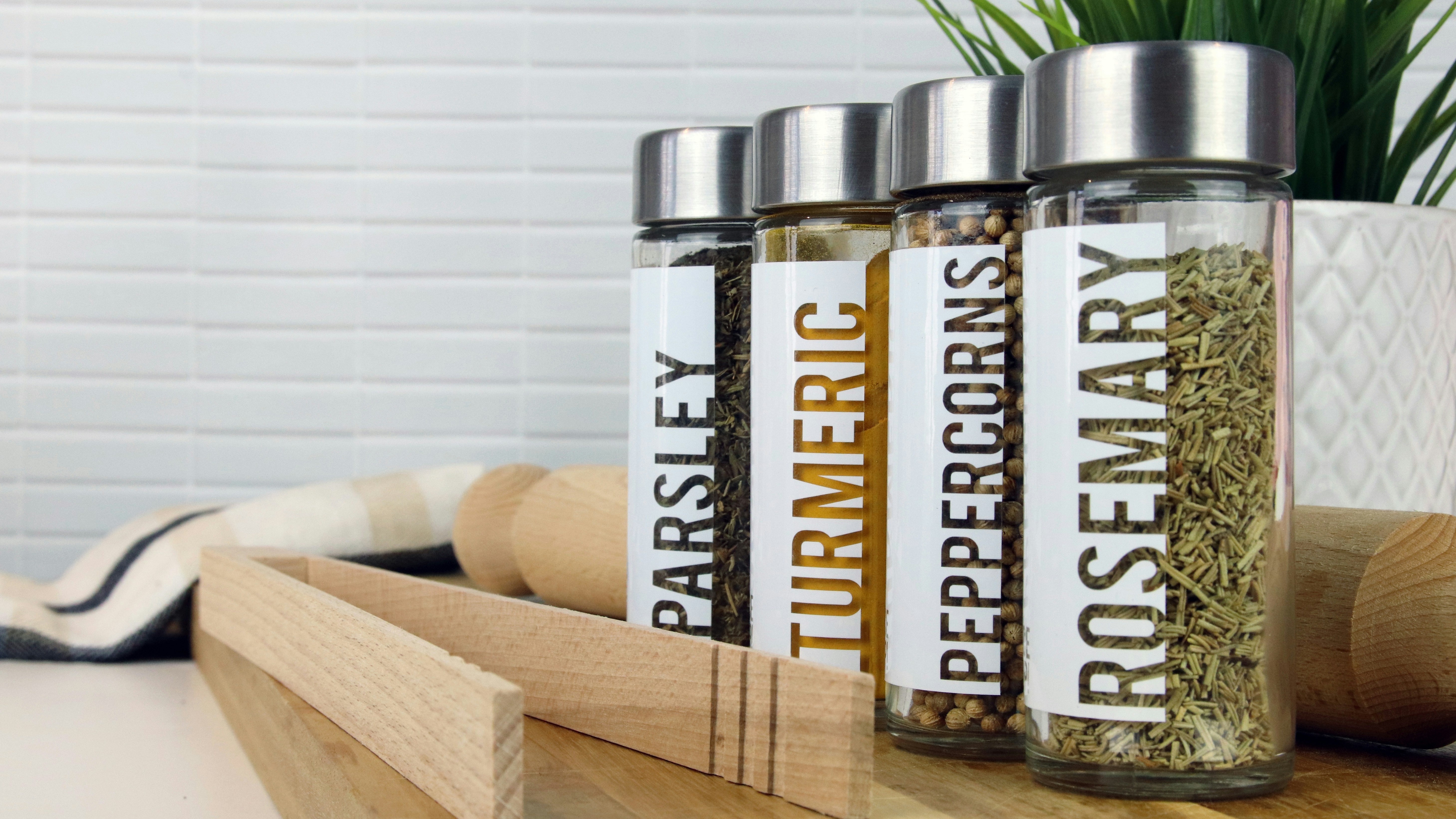 Clear stickers applied to four different glass spice jars