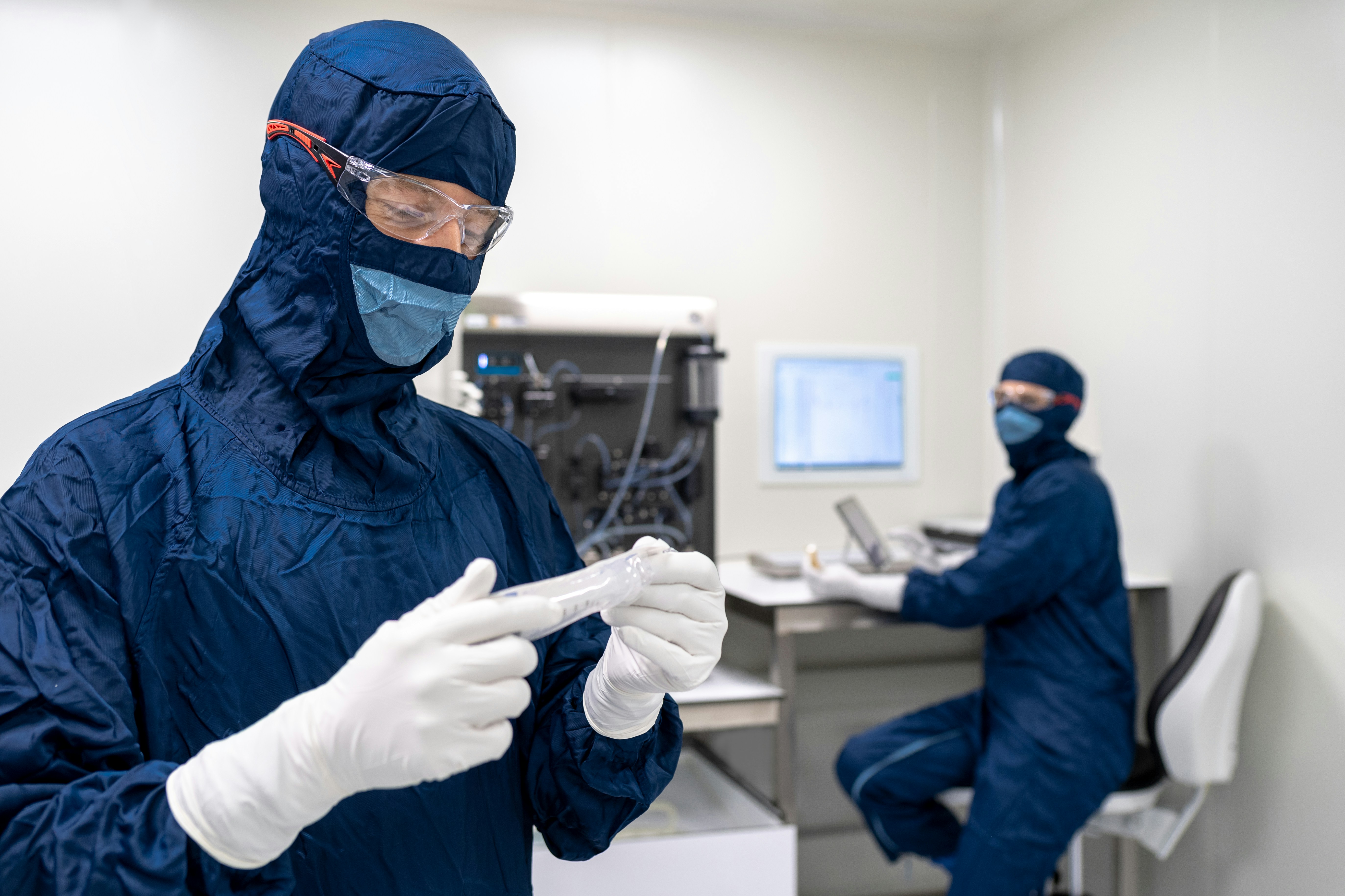 a couple of people in blue protective gear in a room