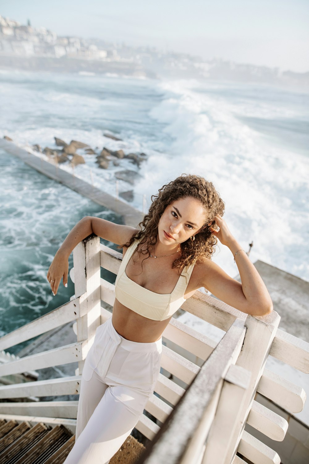 a person sitting on a railing by the water