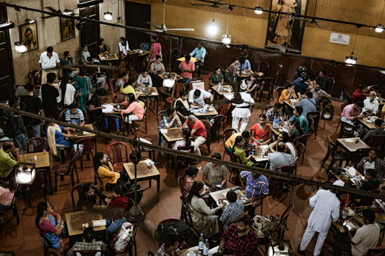 A warm, inviting café scene where diverse adults are laughing and chatting comfortably.