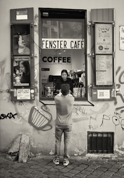 A friendly local helping a traveler with paperwork at a cozy café