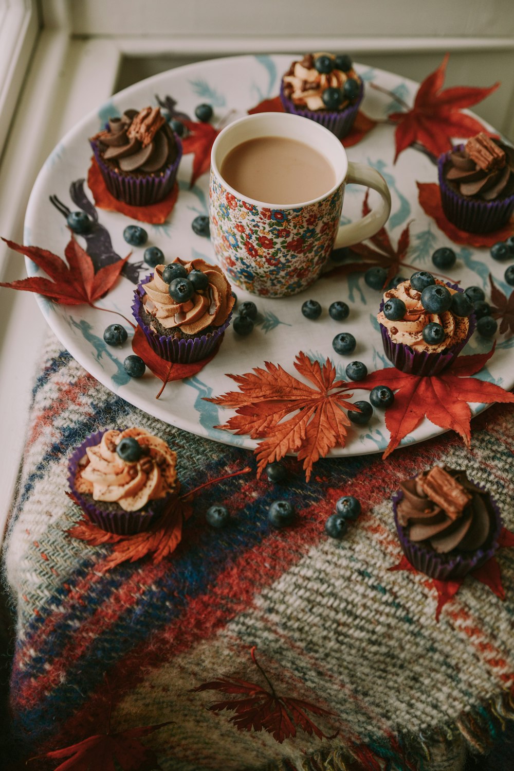 a table with cupcakes and a cup of coffee
