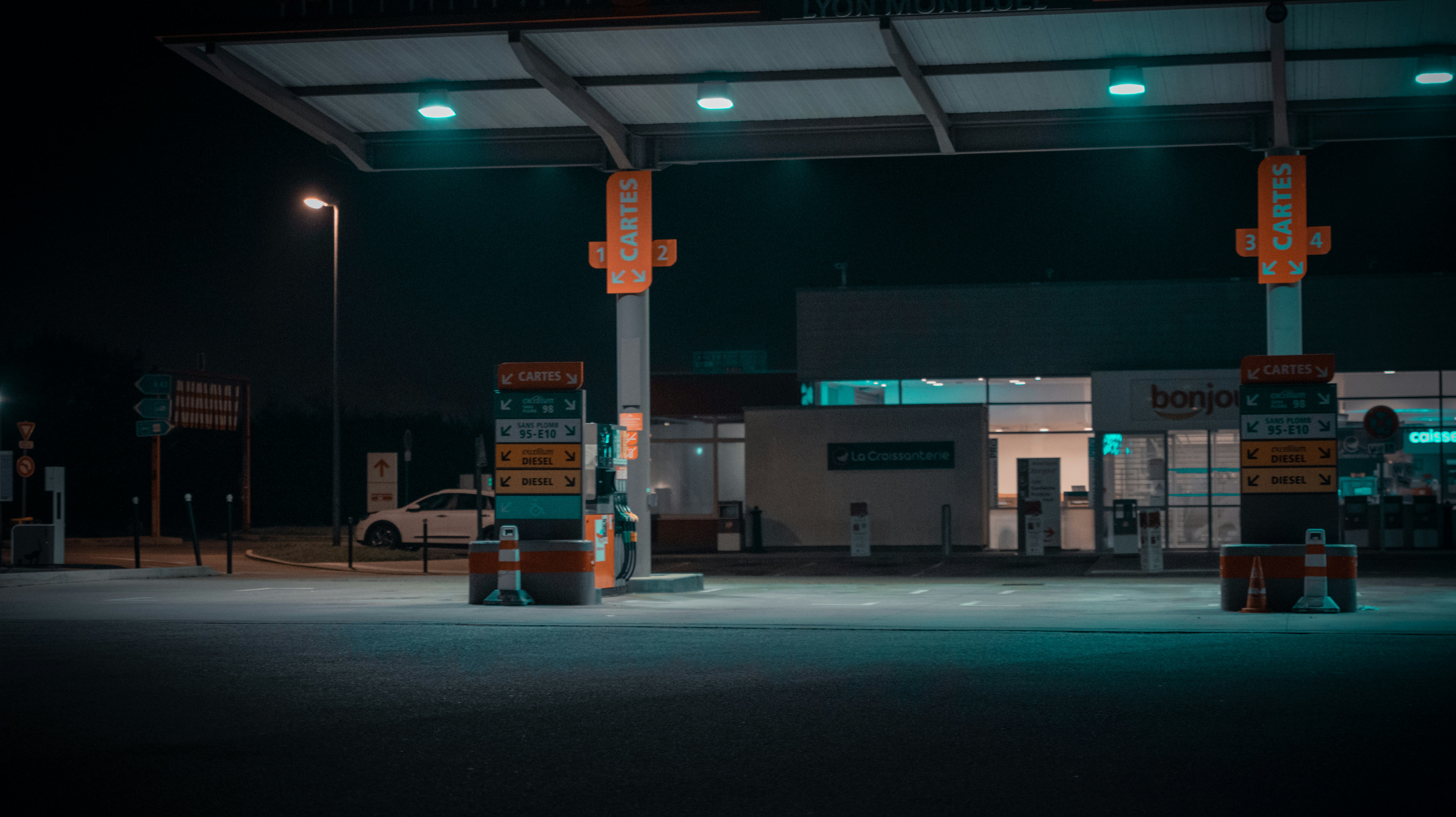 Electric pickup truck charging at night at a public fast-charging station